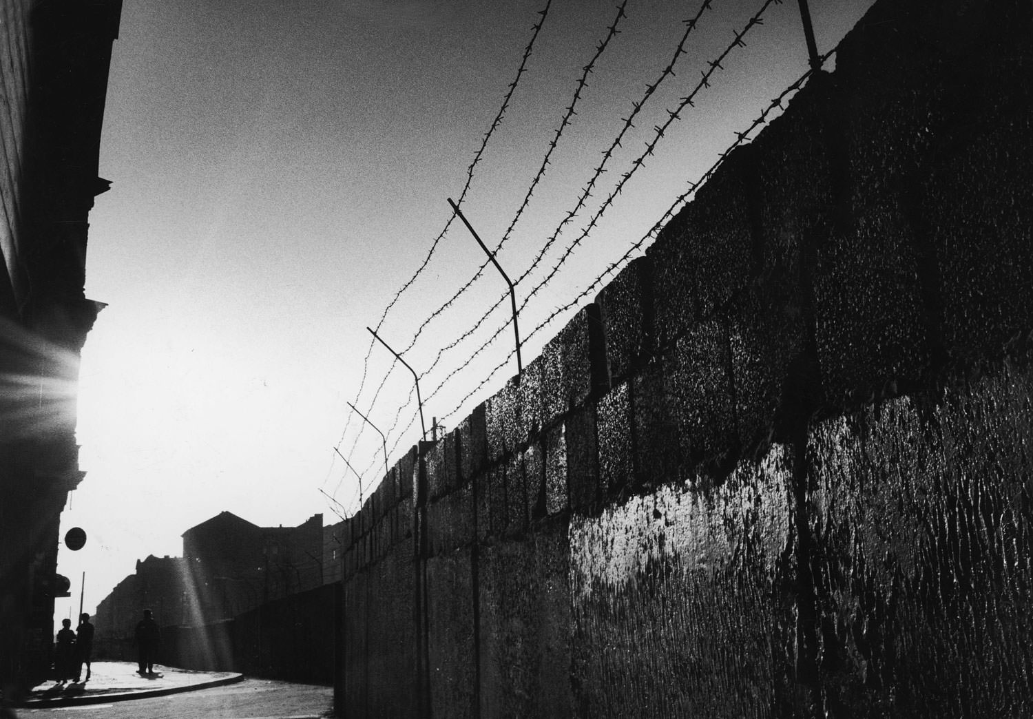 Sunlight shines on the barbed wire and blocks of the Berlin Wall in August 1961.