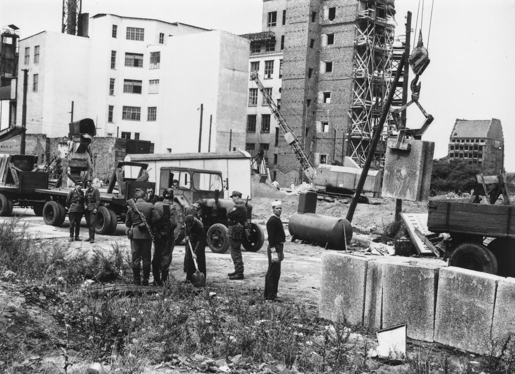 East German military personnel supervising construction of the Berlin Wall in August 1961.