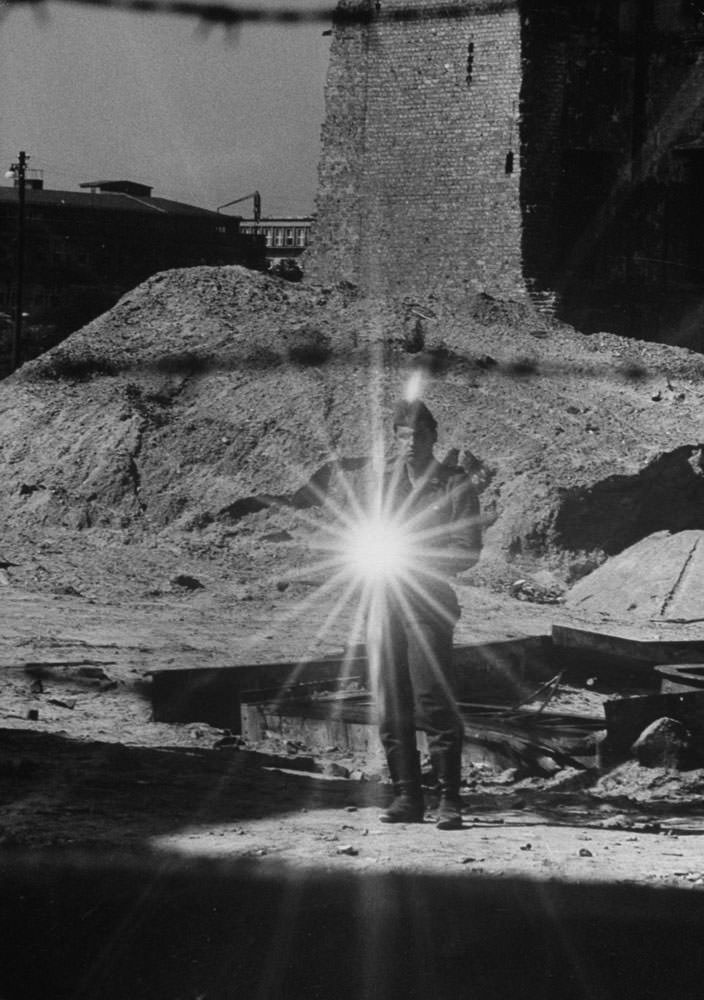 An East German policeman uses sunlight reflected off a mirror in an attempt to stop photographers from taking pictures in August 1961.