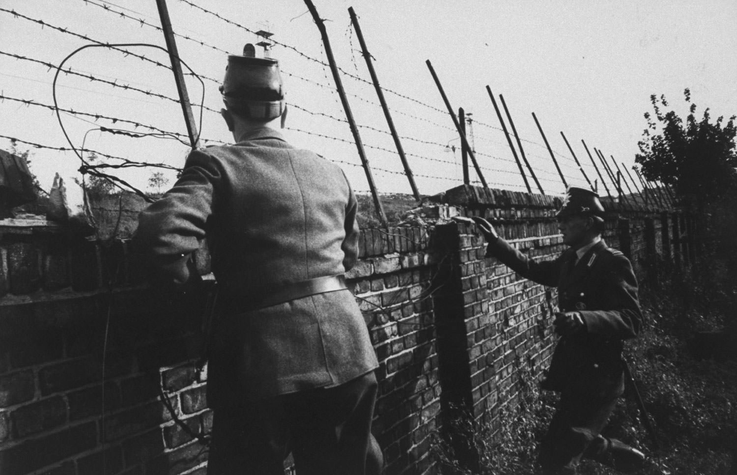 West German police look out over the Berlin Wall in order to offer their help to any potential escapees to the West in October 1961.