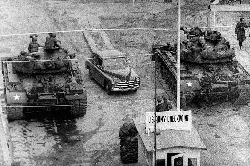 A car rides between US tanks, in October 1961, across the famous border of the American sector in Berlin, at Checkpoint Charlie crossing point, the only one in the Berlin Wall between East