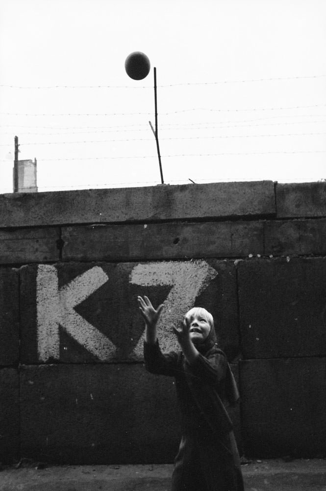 A young West German, Monika Heyne, plays with a ball near the Berlin Wall in January 1962.