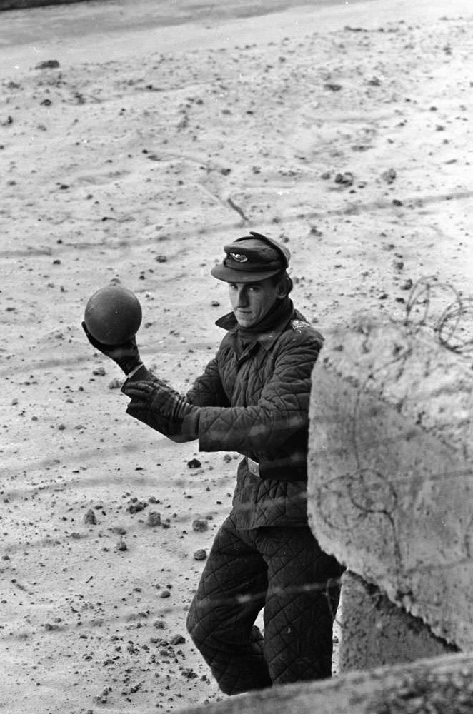 An East German guard throws a ball back to a child on the West German side of the Berlin Wall in June 1962.