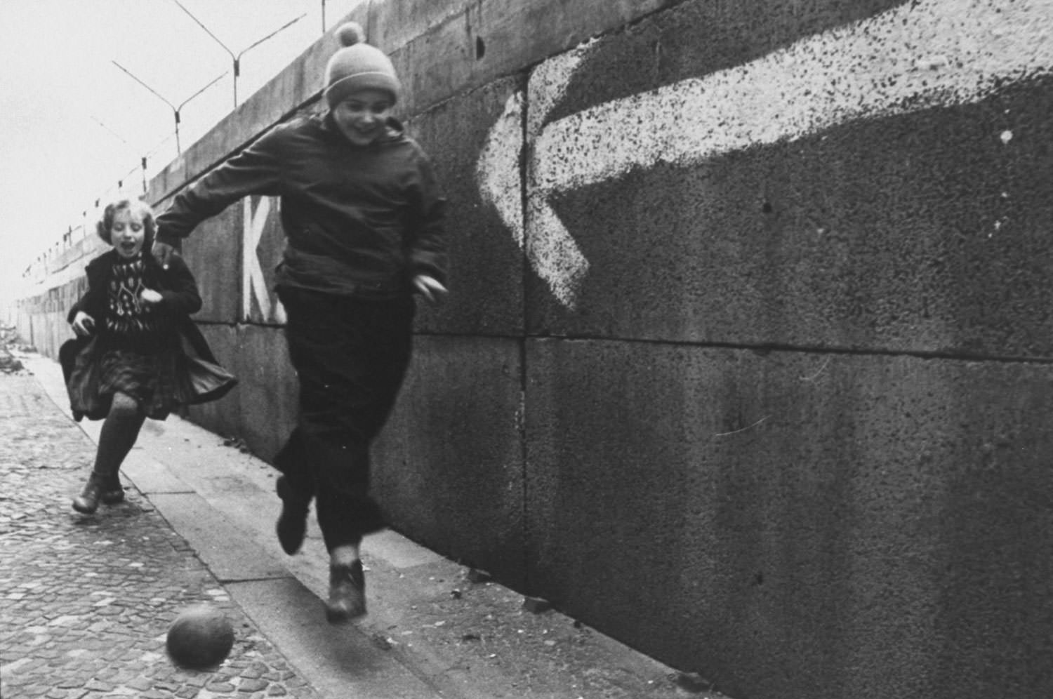 Children chase a ball beside the Berlin Wall in December 1962.