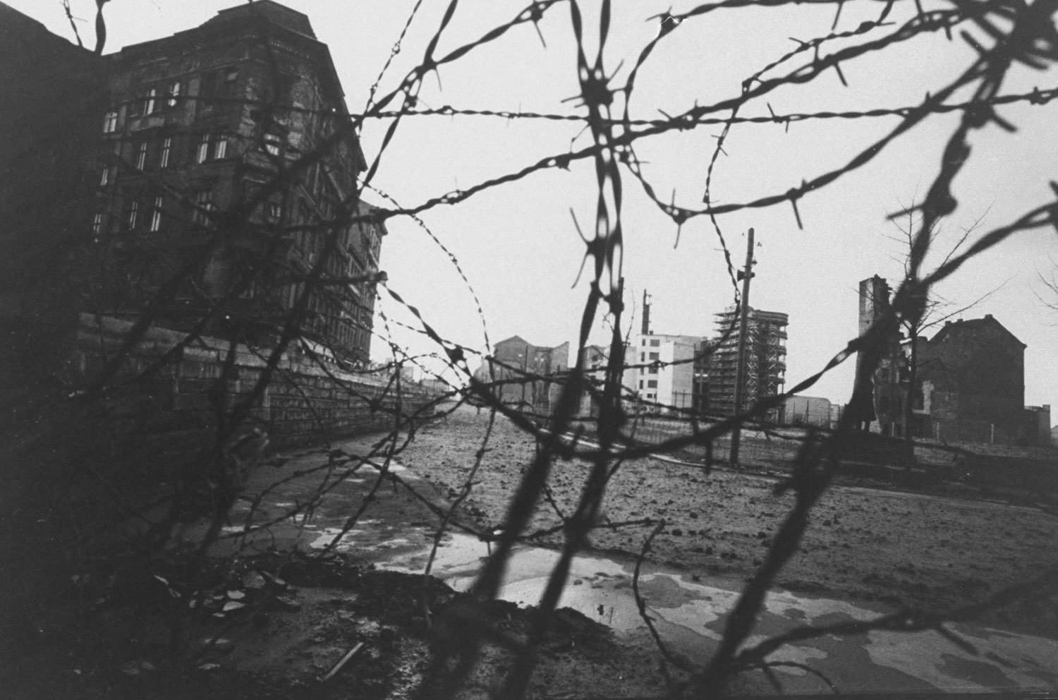 A divided Berlin, seen through a tangle of barbed wire in December 1962.