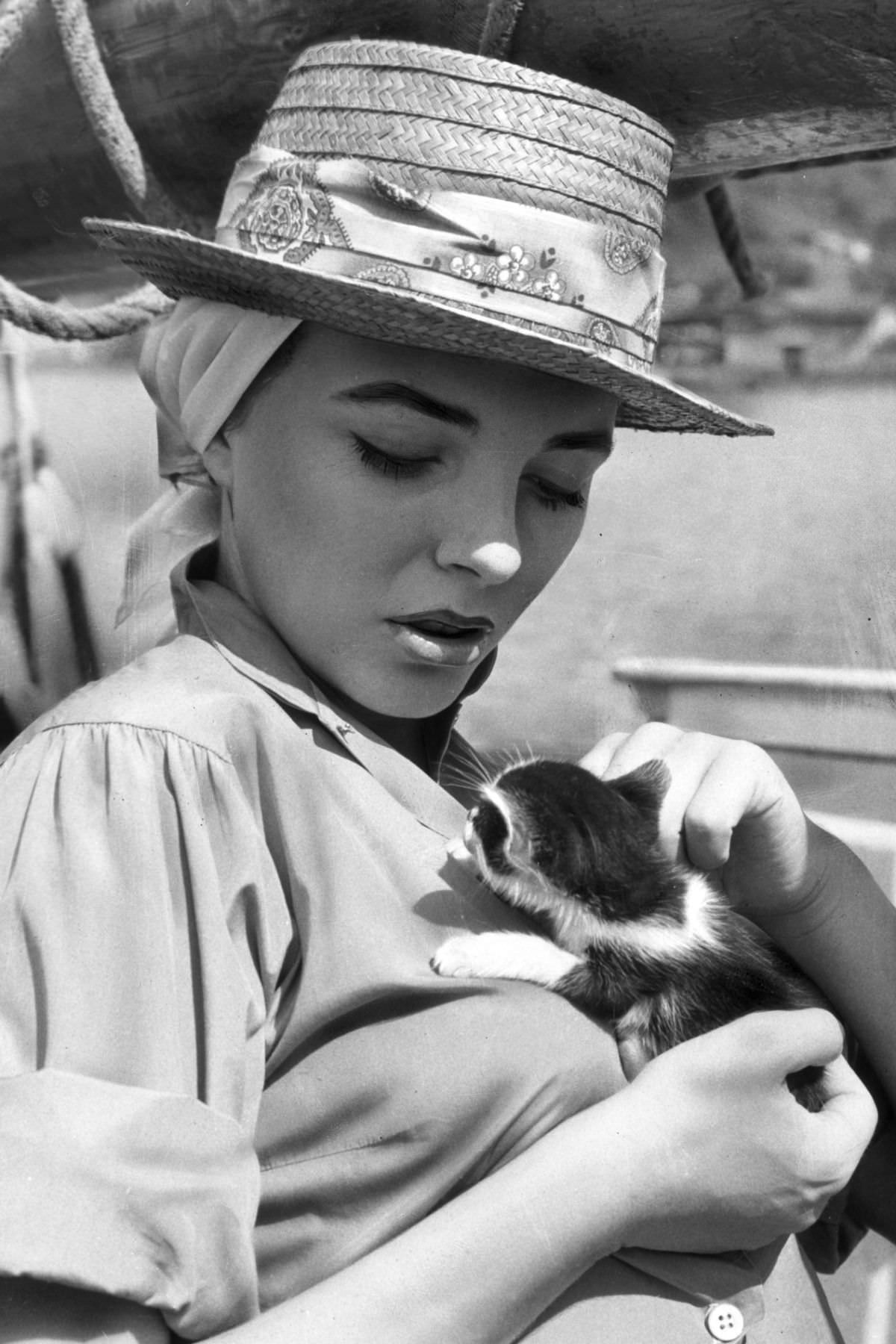 British-born actress Joan Collins lounged on a boat that came with its own kitten, 1957.