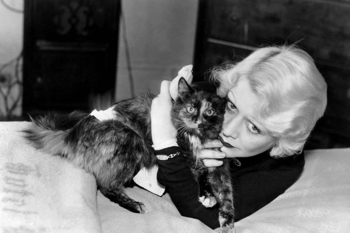 The Maltese Falcon actress Gladys George hugs her tortoiseshell cat, whom she named Monkie.