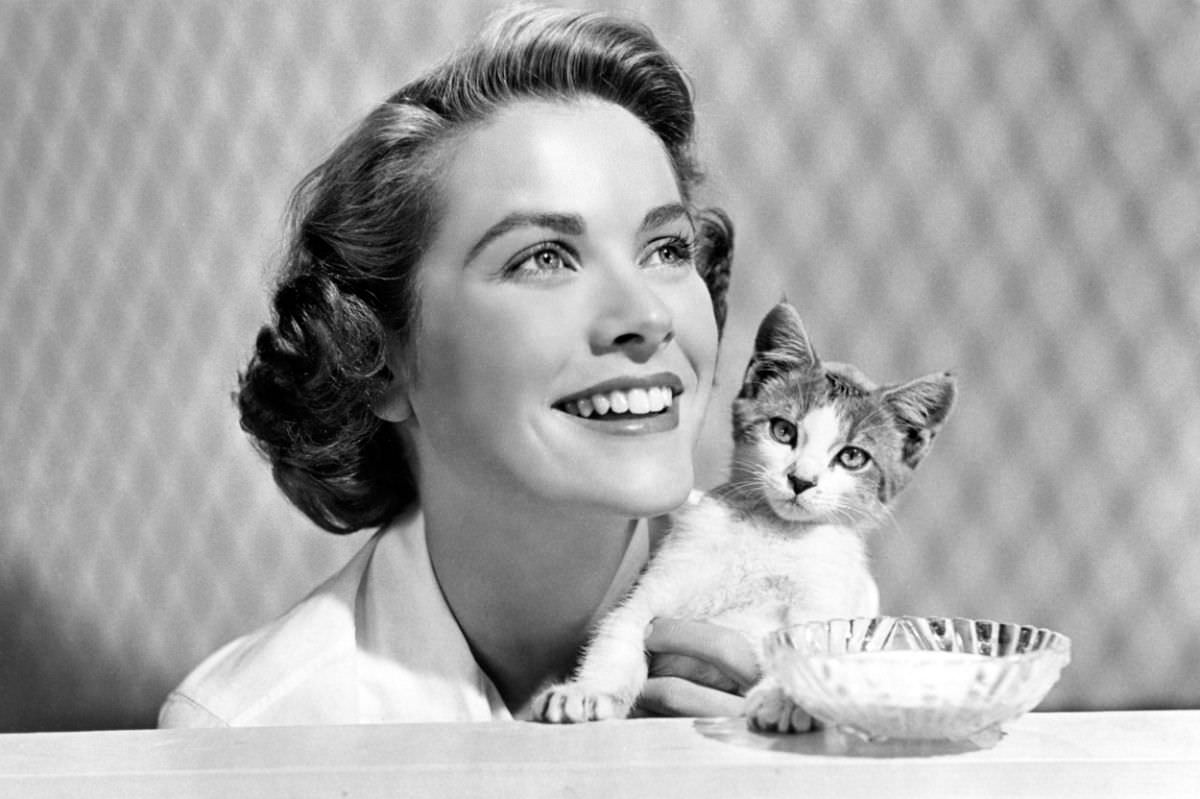 Grace Kelly clutching a kitten while working as a part-time model, some eight years before she would become the Princess of Monaco, 1944.