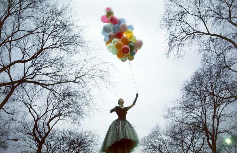 Faye Dunaway is holding a bunch of balloons in Central Park, New York City, 1969