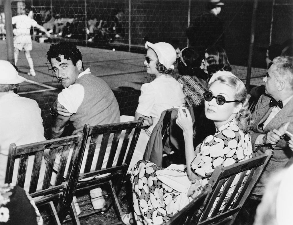 Constance Bennett sitting with Mexican leading man Gilbert Roland at Beverly Hills Tennis club, 1932.