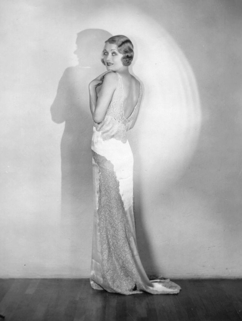 Constance Bennett modelling a slinky backless evening dress, 1936.