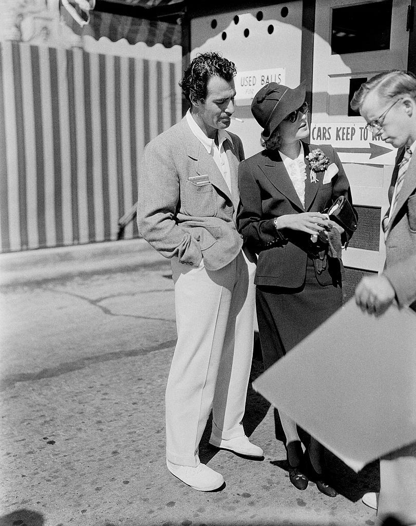 Gilbert Roland and actress Constance Bennett talk to a fan in Los Angeles, 1940.