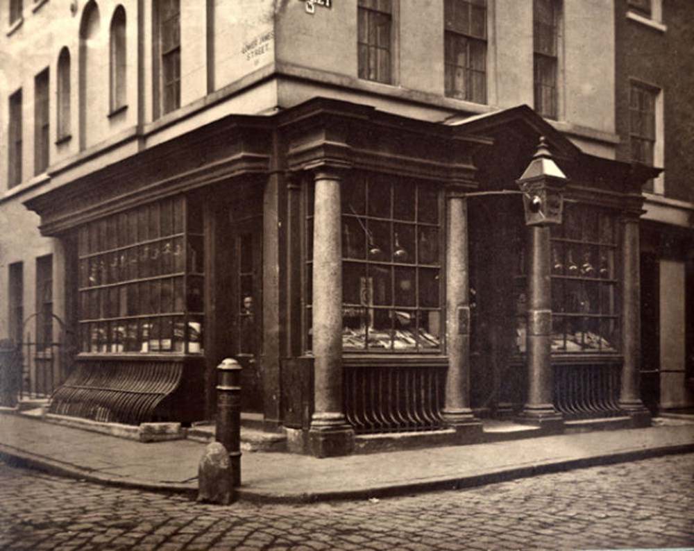 A man peers from the window of a chemists’ at the corner of Lower James St and Brewer St.