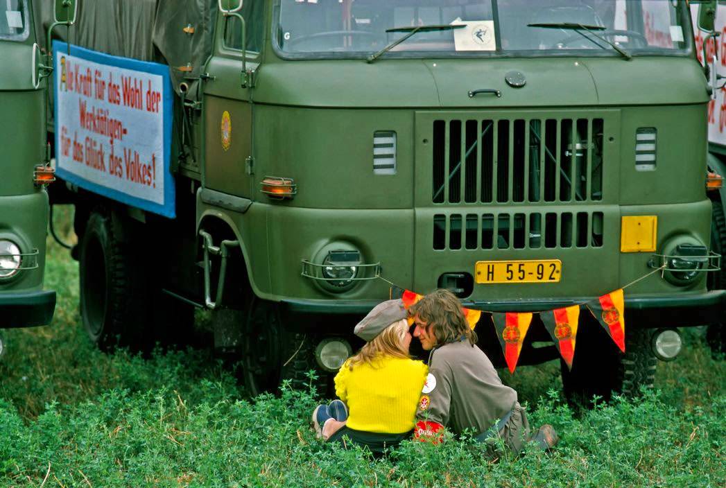 Uniformed couple flirting during a military air show in Magdeburg. Magdeburg, 1974.