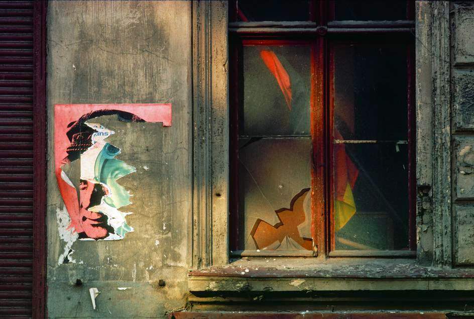 A wall with torn posters of Ernst Thaelmann and an East German flag behind broken glass in the Prenzlauer Berg district, East Berlin, 1974
