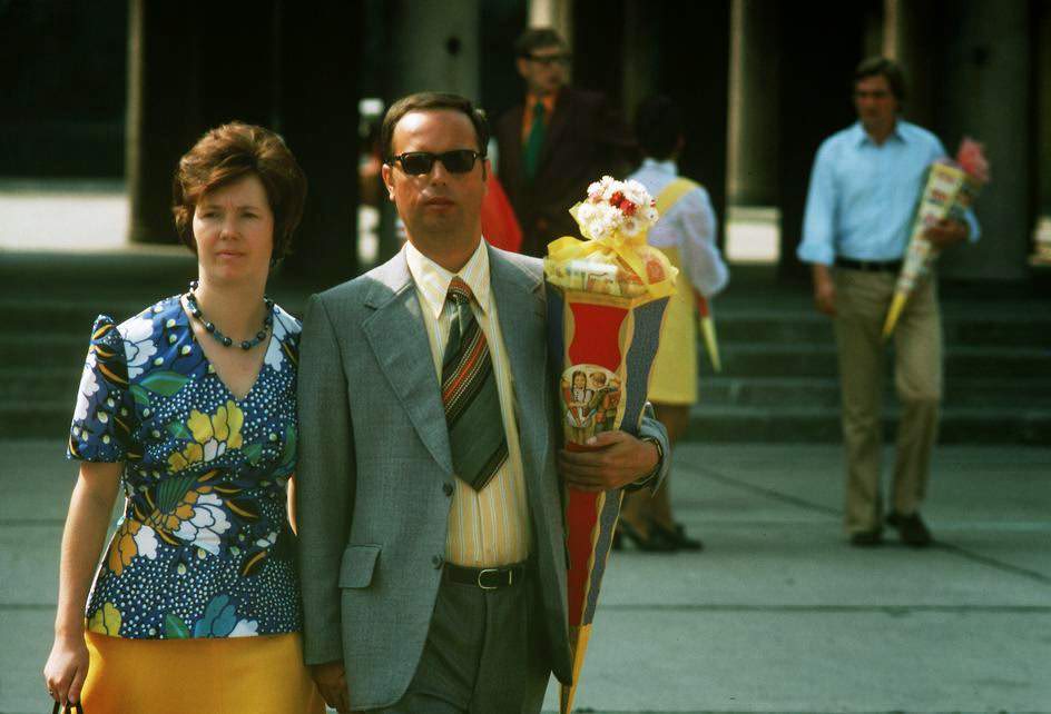 Proud parents carry a traditional candy bag on the first day of school for their in Berlin-Friedrichshain. East Berlin, 1974