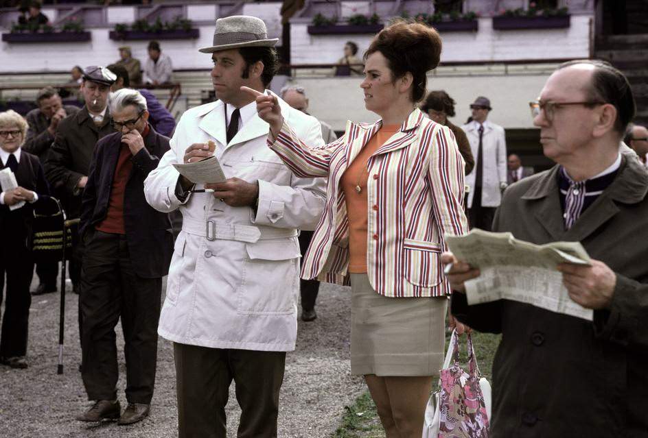 Spectators betting on a horse race at the Hoppegarten trotting course. East Berlin, 1974