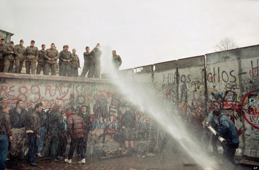 East German border guards use a hose to discourage West Berliners near Brandenburg gate, in Berlin, Nov. 11, 1989.