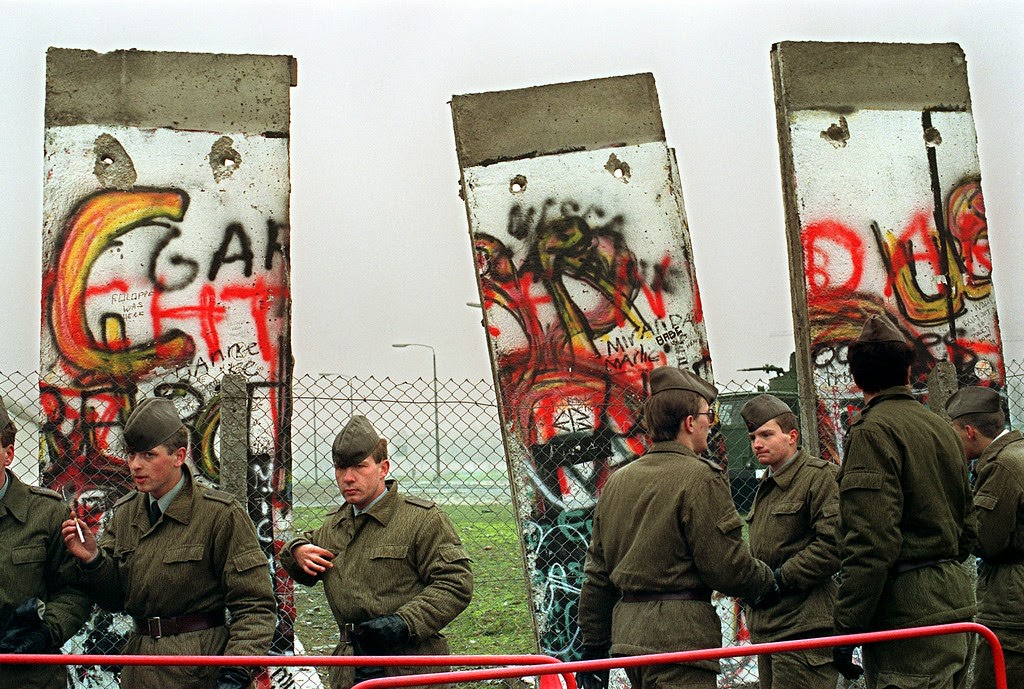 East German border guards demolishing a section of the Berlin wall in order to open a new crossing point between East and West Berlin, 11 November 1989 at the border line near the Potsdamer Square.