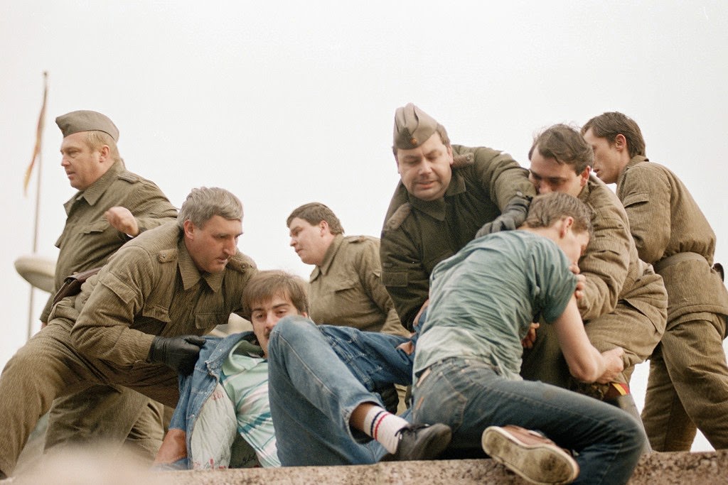 Berliners confront with East German policemen atop the Berlin Wall early 11 November 1989, near the Potsdamer Square.