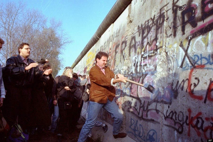 An unidentified West Berliner swings a sledgehammer, trying to destroy the Berlin Wall near Potsdamer Platz, on November 12, 1989, where a new passage was opened nearby.