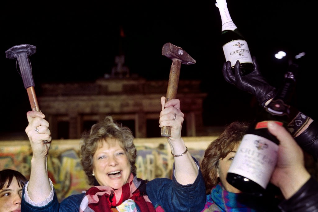 A berliner holds up a hammer and a chisel early on November 15, 1989 in front of the wall at the Brandebourg Gate