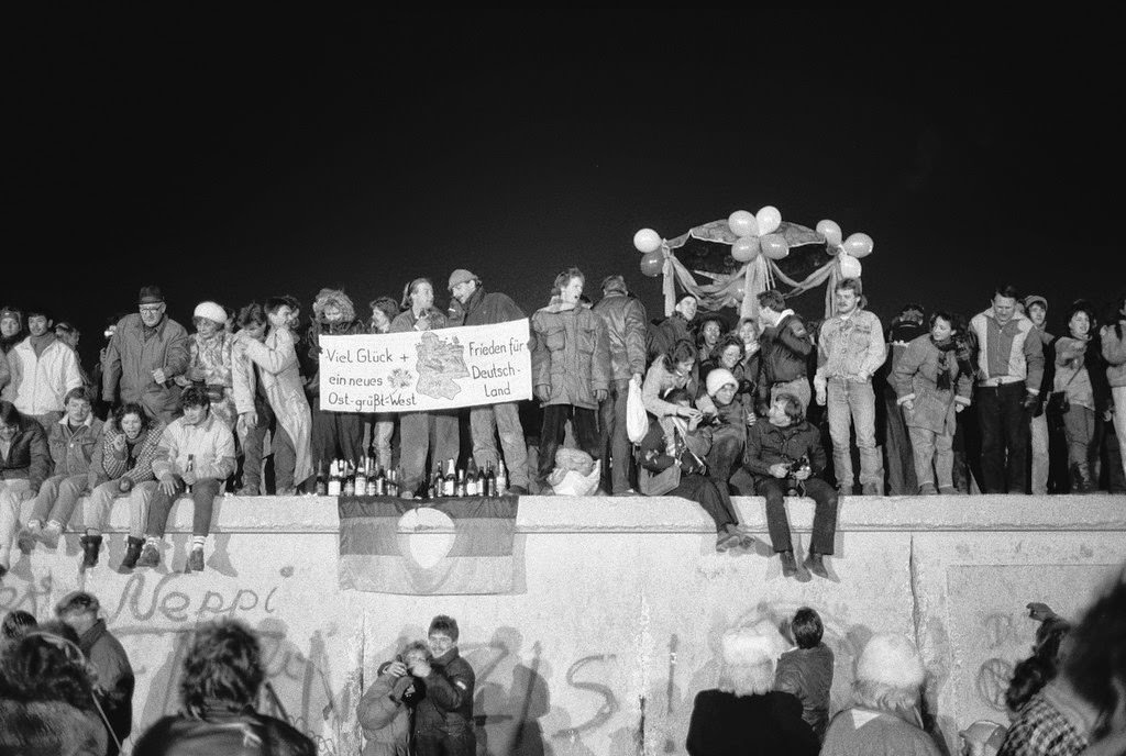 A view from the east of Berliners gathered on the Berlin Wall to celebrate the New Year and the effective end of the city's partition, 31st December 1989.