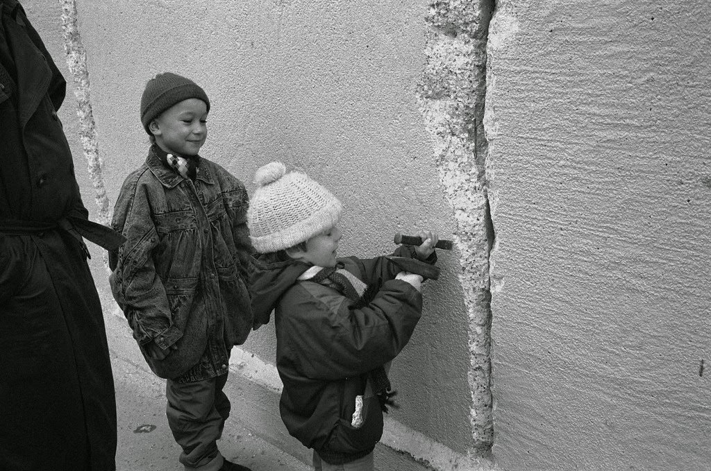 An East German boy chips away at a section of the Berlin Wall at the effective end of the city's partition, 31st December 1989.