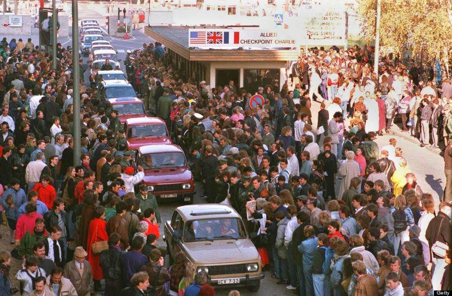 A long row of East German Trabant cars passing through Checkpoint Charlie into West Berlin is greeted by enthusiastic West Berliners, 10th November 1989.