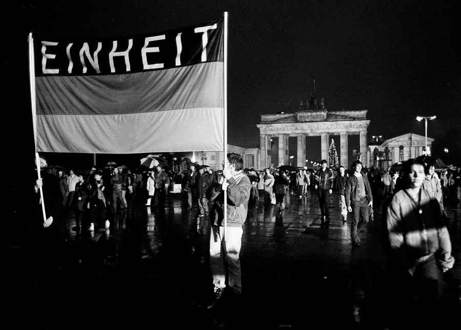 This flag, reading "Unity," was waved high as these Germans crossed the newly opened border December 22.