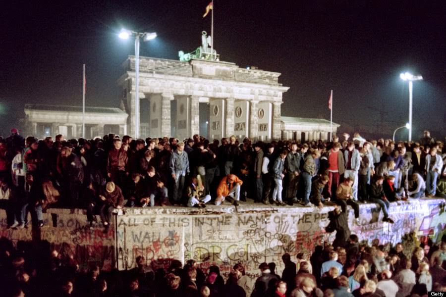 Thousands of young East Berliners crowd atop the Berlin Wall, near the Brandenburg Gate (background) on November 11, 1989.