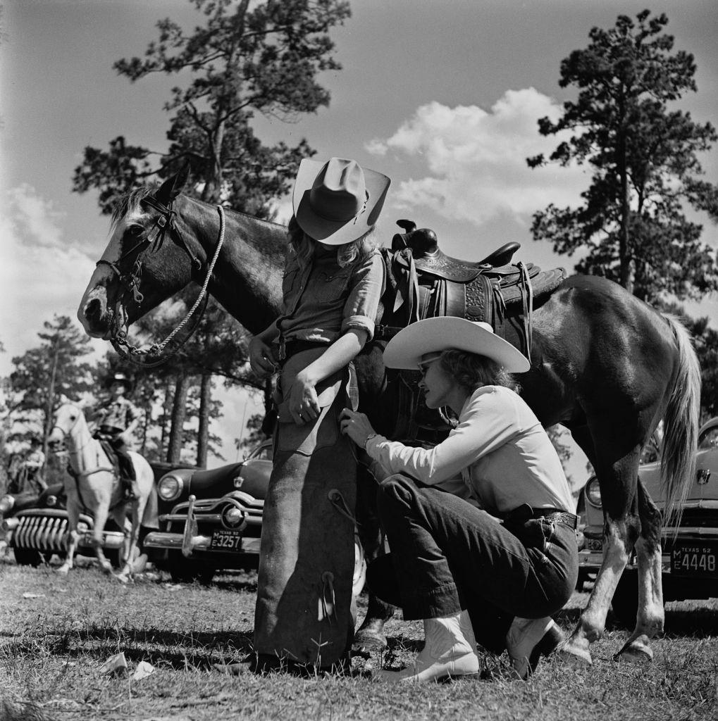 A woman helps a young contestant at a youth rodeo in Houston, Texas, 29th May 1952.