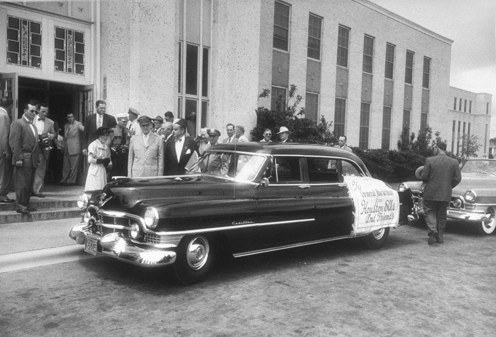 Gen. Douglas MacArthur (L, in uniform) and wife admiring new Cadillac given as gift of Houston Elks, 1951.