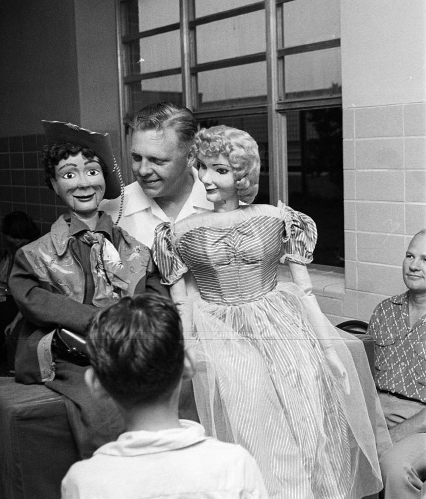 Man holding puppets during a blood drive, Houston, Texas, 1953