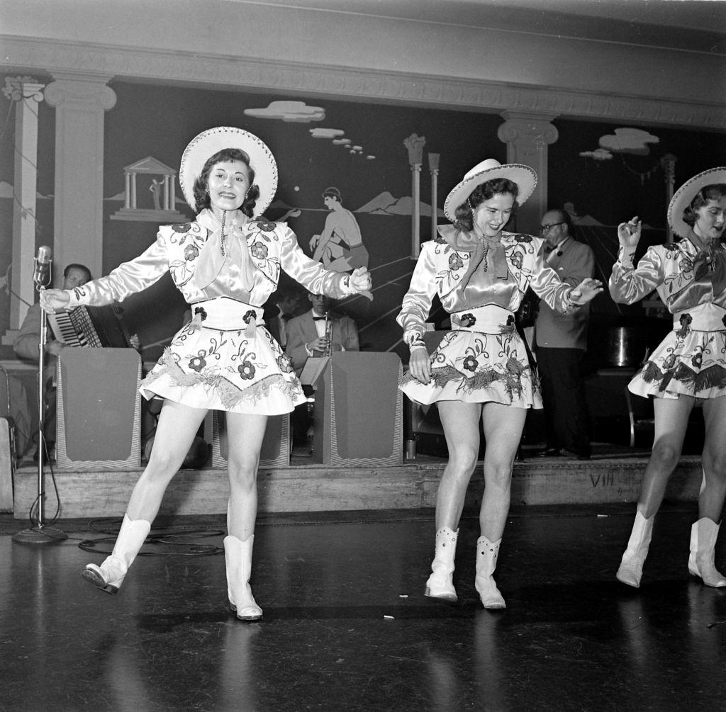 Women in cowgirl costumes performing at a Houston charity ball in Houston, 1953.