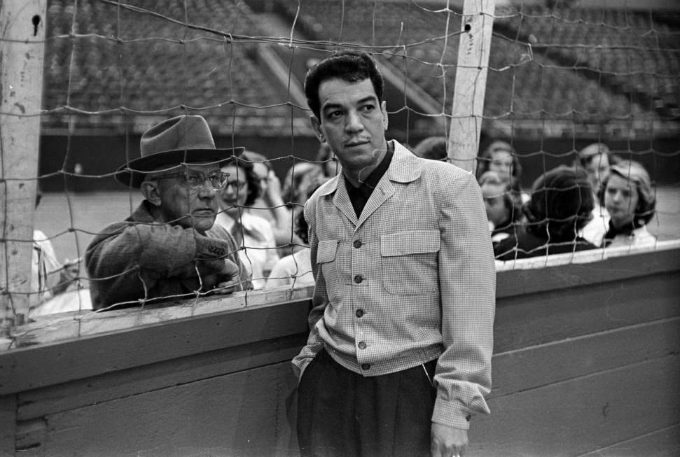 Comedian Mario Moreno standing on fence, Houston, 1952.