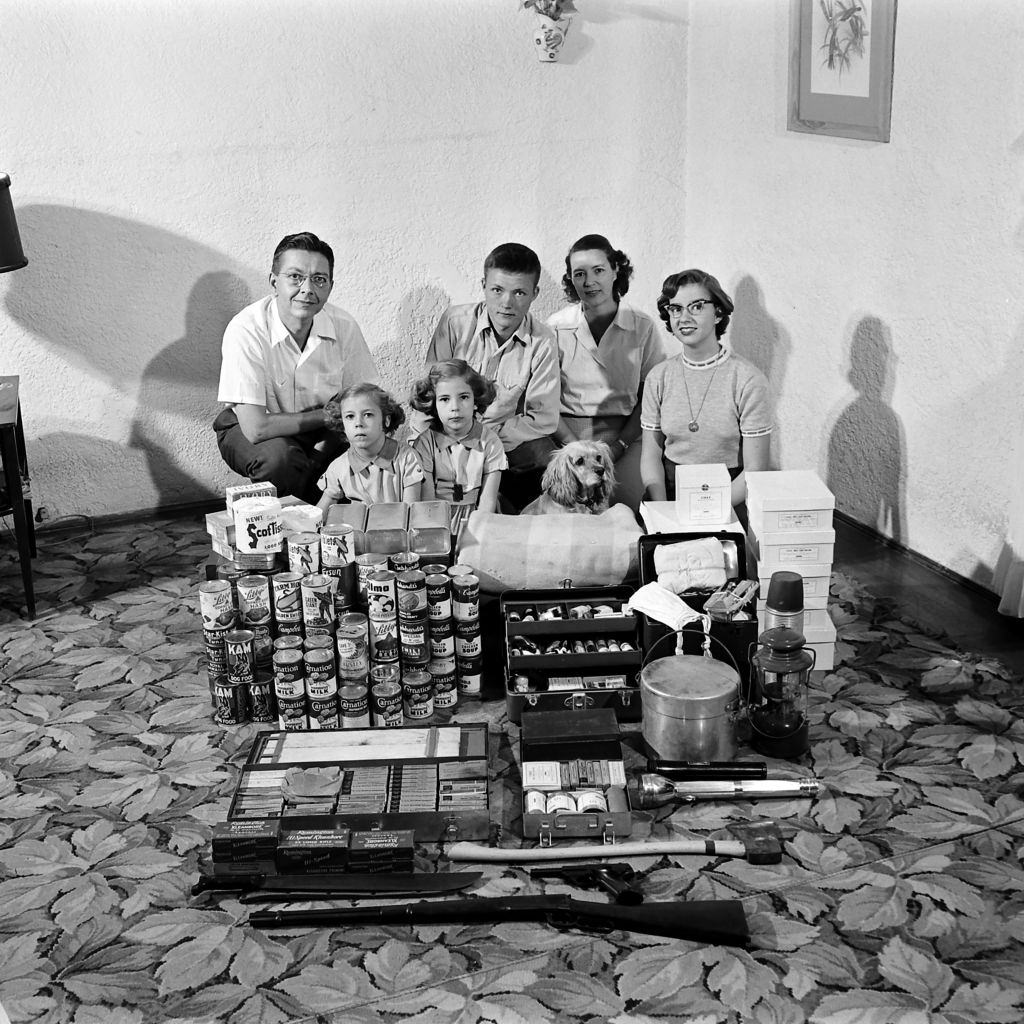 Family preparing for atomic war posing with food and first aid supplies for their makeshift bomb shelter in Houston, Texas, March 1954.