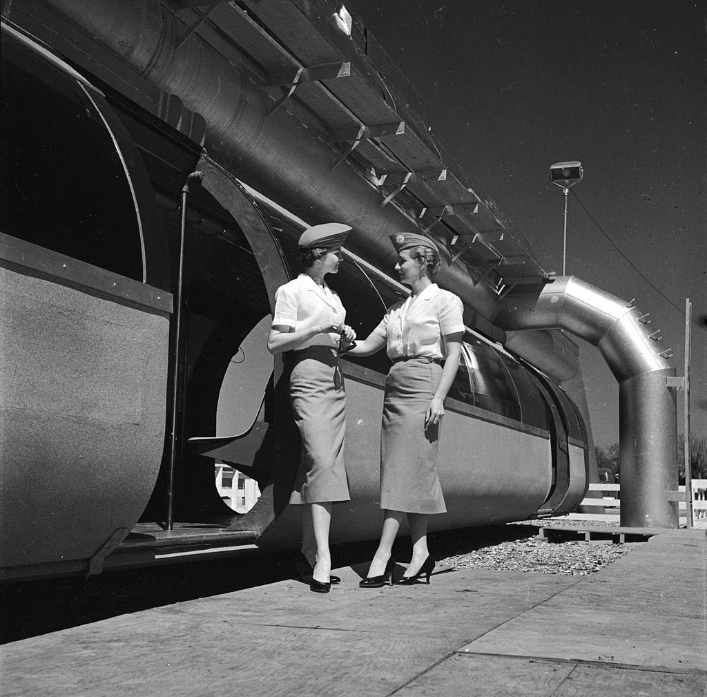 Two hostesses stand in front of a new monorail service in Houston, 1950s.