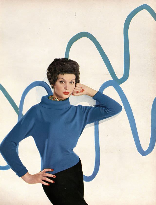 Isabella Albonico in deep blue cashmere sweater with big wide turtleneck collar by Braemar, worn with faux emerqalds by Hattie Carnegie. Harper's Bazaar, August 1957