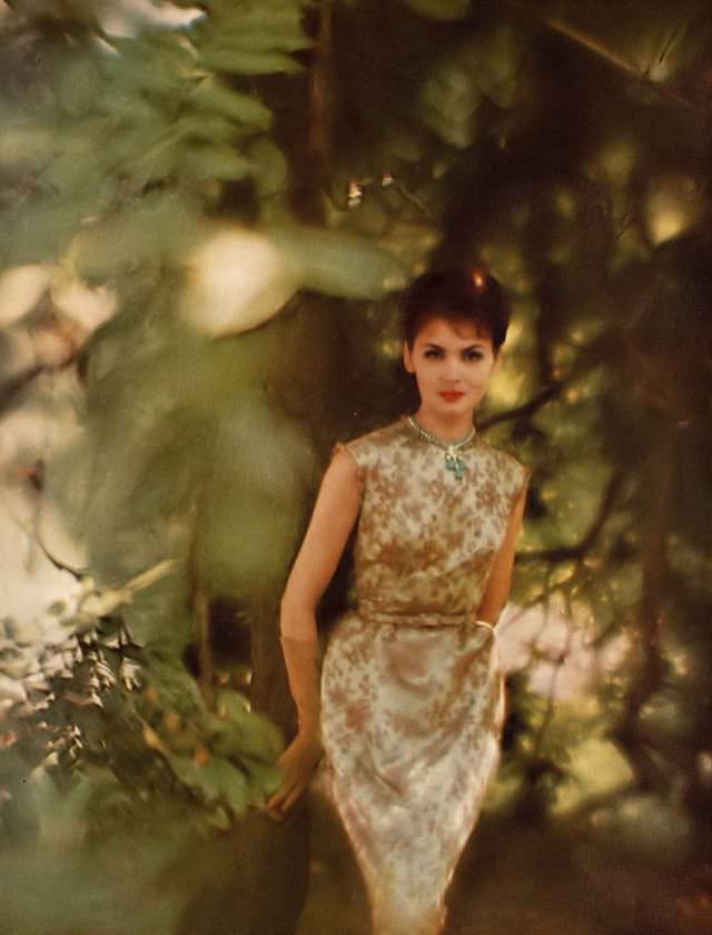 Isabella in pale blue satin dress under flowery cafe-au-lait Chantilly lace, by Jane Derby, turquoise and diamond necklace by Van Cleef & Arpels. Harper's Bazaar, October 1959