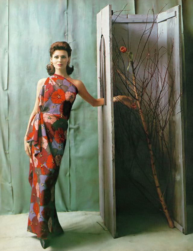 Isabella Albonico in asymmetric evening gown of colorful floral print in Bianchini silk by Galanos, Miriam Haskell earrings. Harper's Bazaar, April 1960