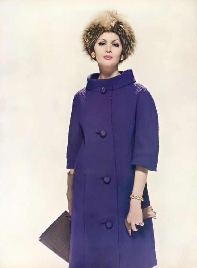 Isabella Albonico in slim purple wool coat with stand-away collar by Monte Sano & Pruzan, hat by Sally Victor, jewelry by Cartier. Vogue, October 1, 1960