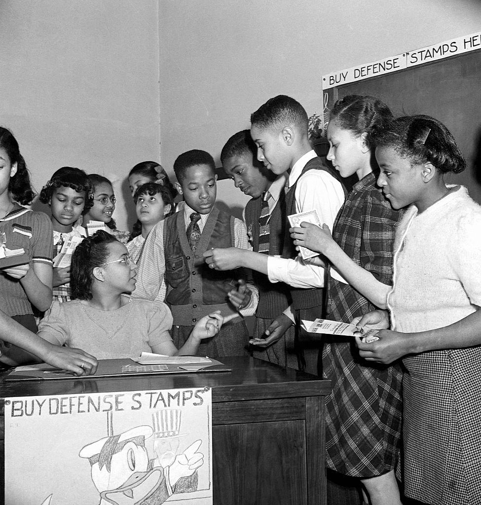 A group of students at a Negro high school buying and selling defense stamps, 1942.