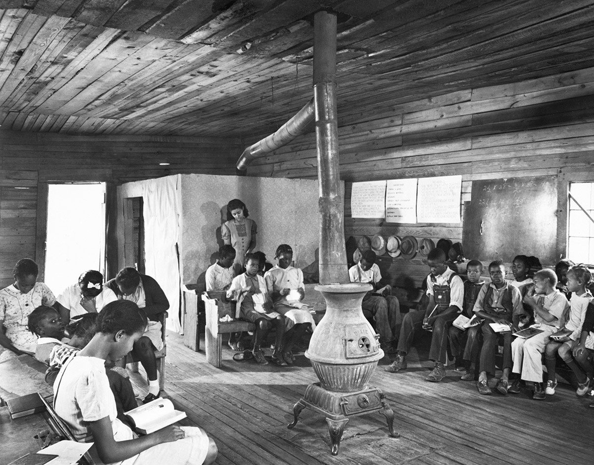 A teacher instructs a segregated class of black students at a poorly funded, one-room school in the backwoods of Georgia in 1941.