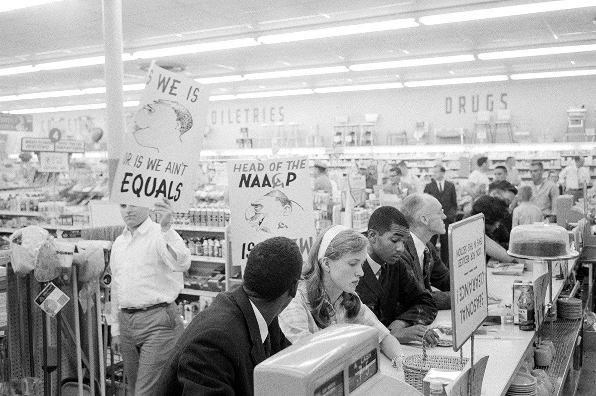 Demonstrators staging a sit-in at a drugstore lunch counter in Arlington, Virginia, are picketed by members of the American Nazi Party in 1960.