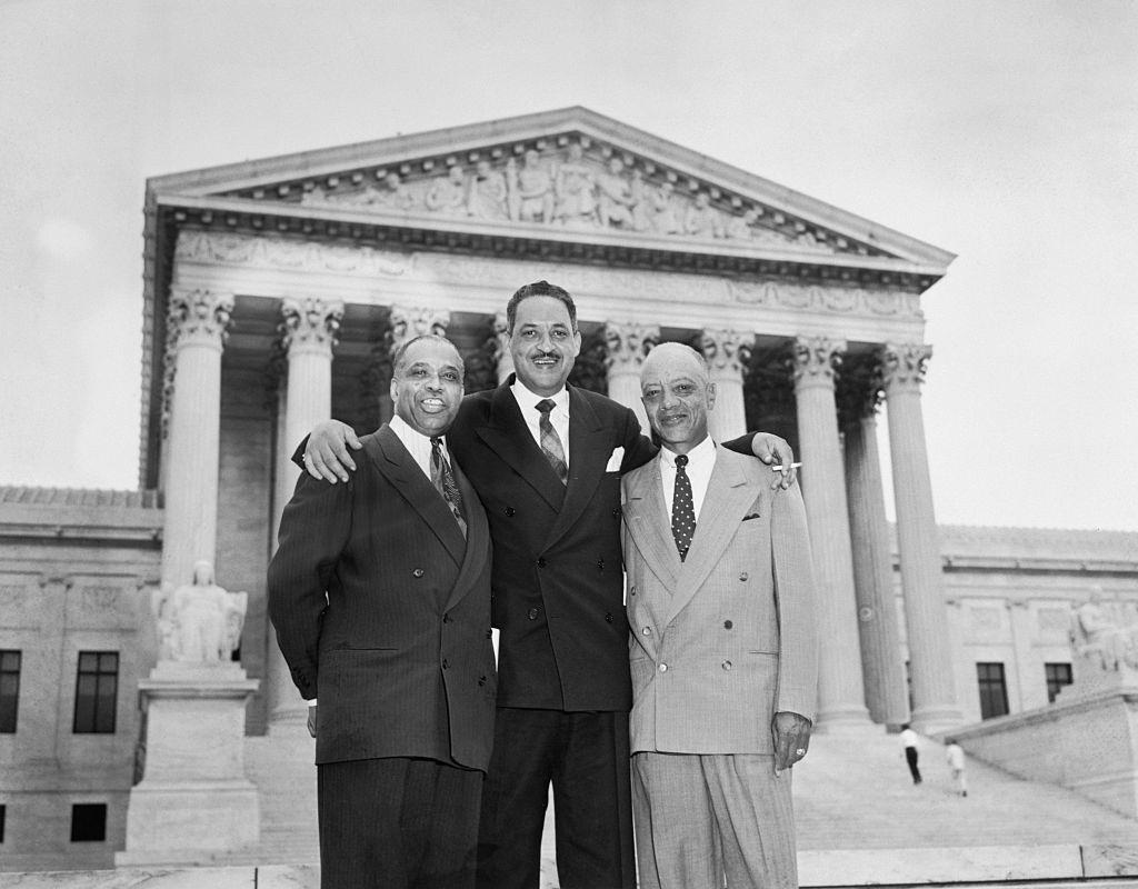 Attorneys who argued the case against segregation stand together smiling in front of the U. S. Supreme Court Building, 1954.