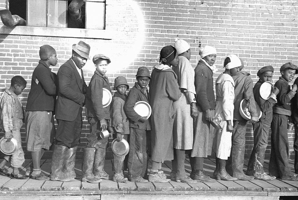 Flood refugees lined up and waiting for food at a temporary camp for African Americans. Forrest City, Arkansas, February 1937.