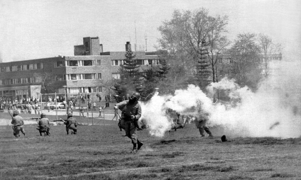 National Guard troops throw tear gas into the rioters at Kent State protesting the American invasion of Cambodia.