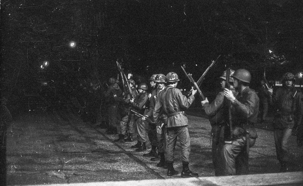 Youths run from tear gas thrown by police to break up a window smashing rampage by students of Kent State University demonstrating the war.