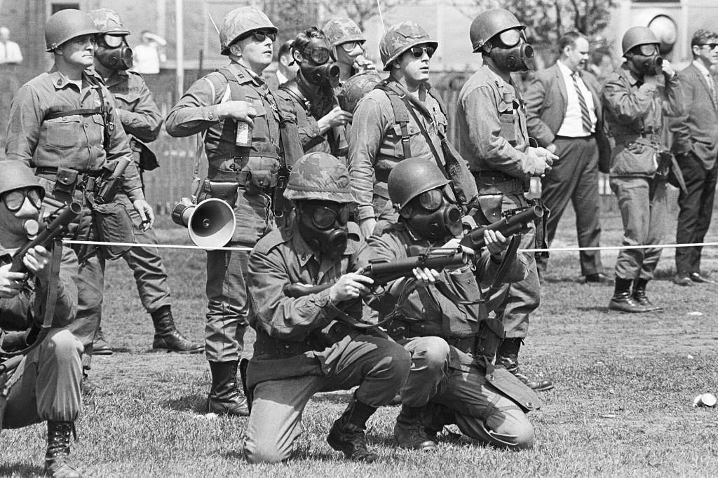 Masked national guardsmen fire barrage of tear gas into crowd of demonstrators on campus of Kent State University, May 4th 1970.